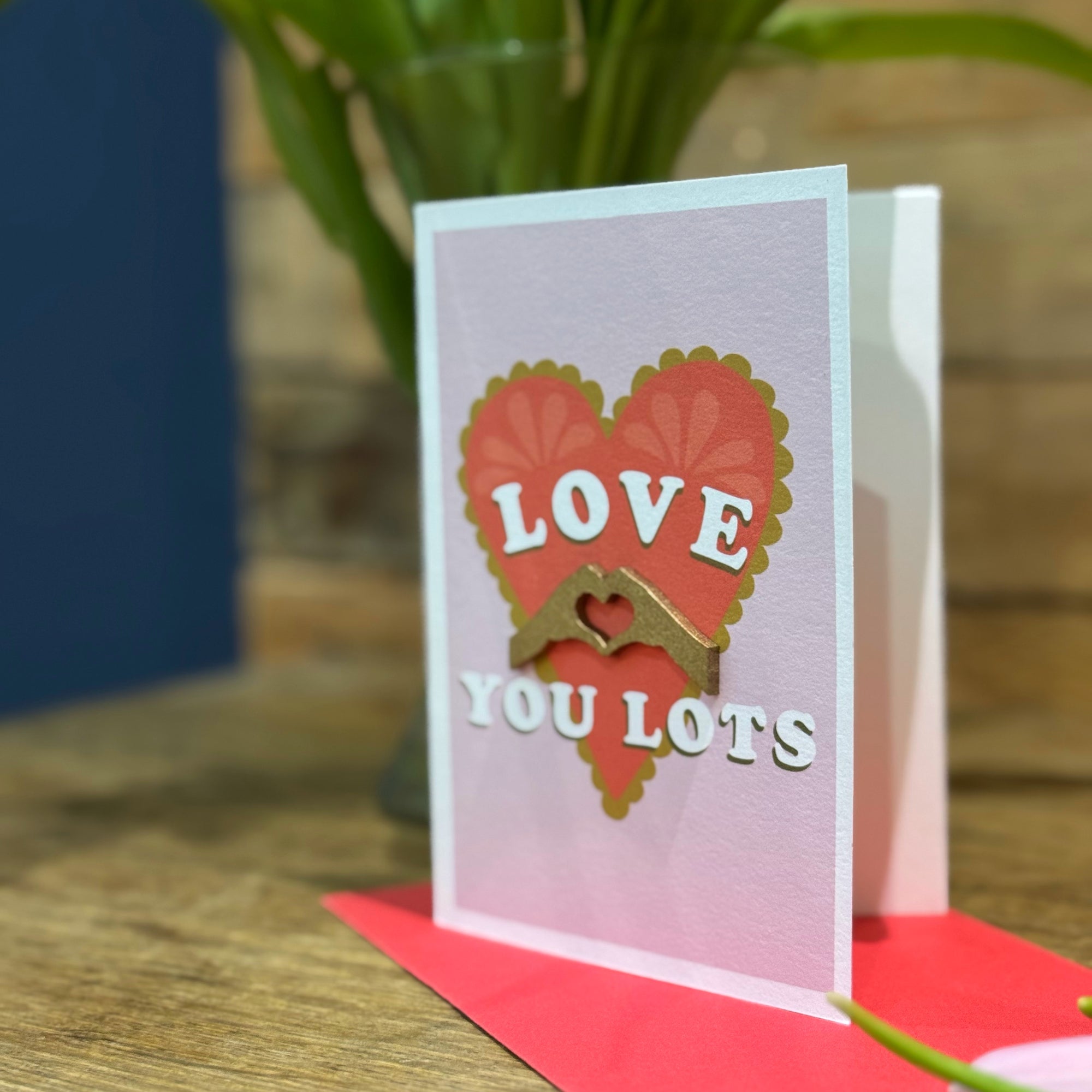 3D golden hands making heart shape on red heard card