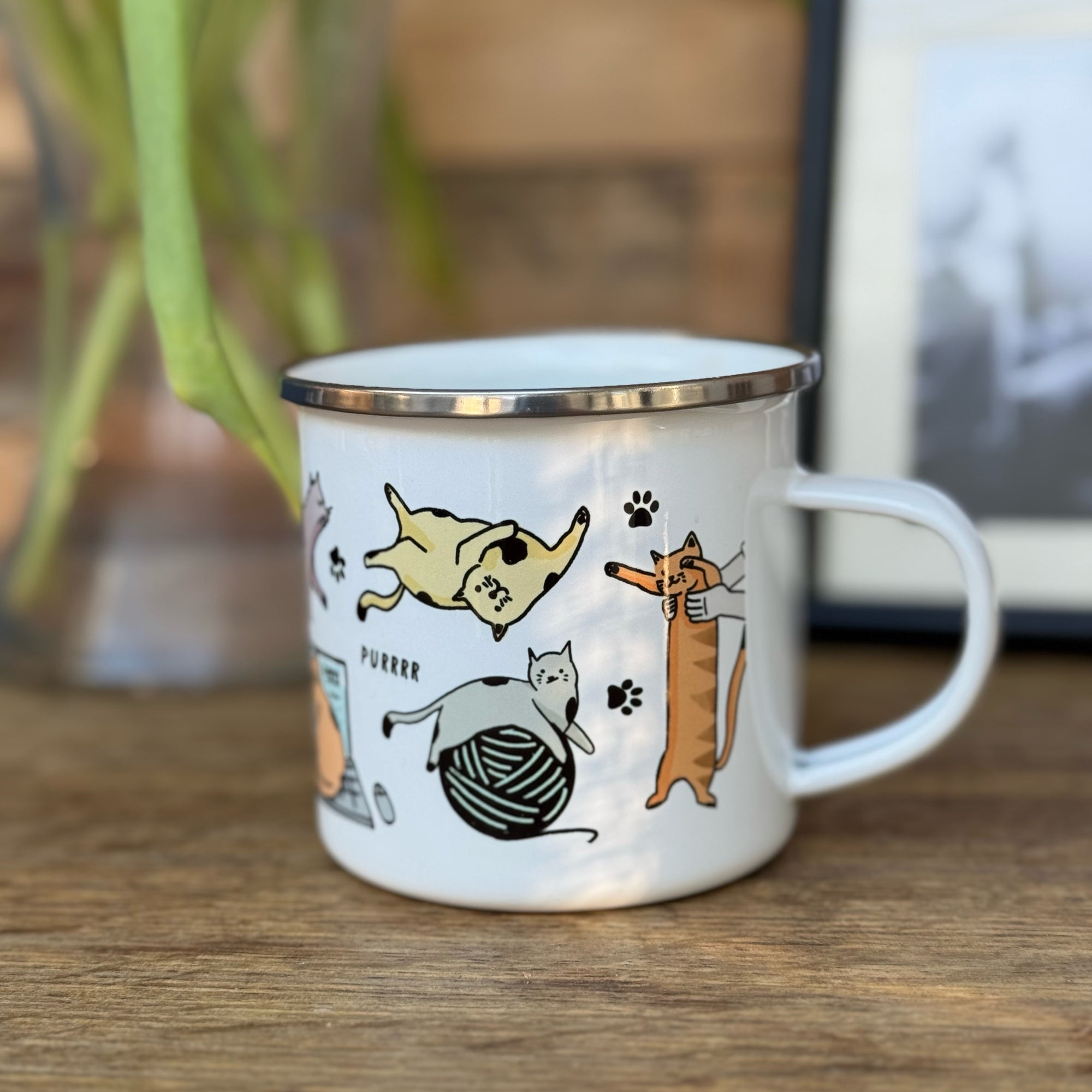 A bright white metal mug with a colourful array of Cat Illustrations
