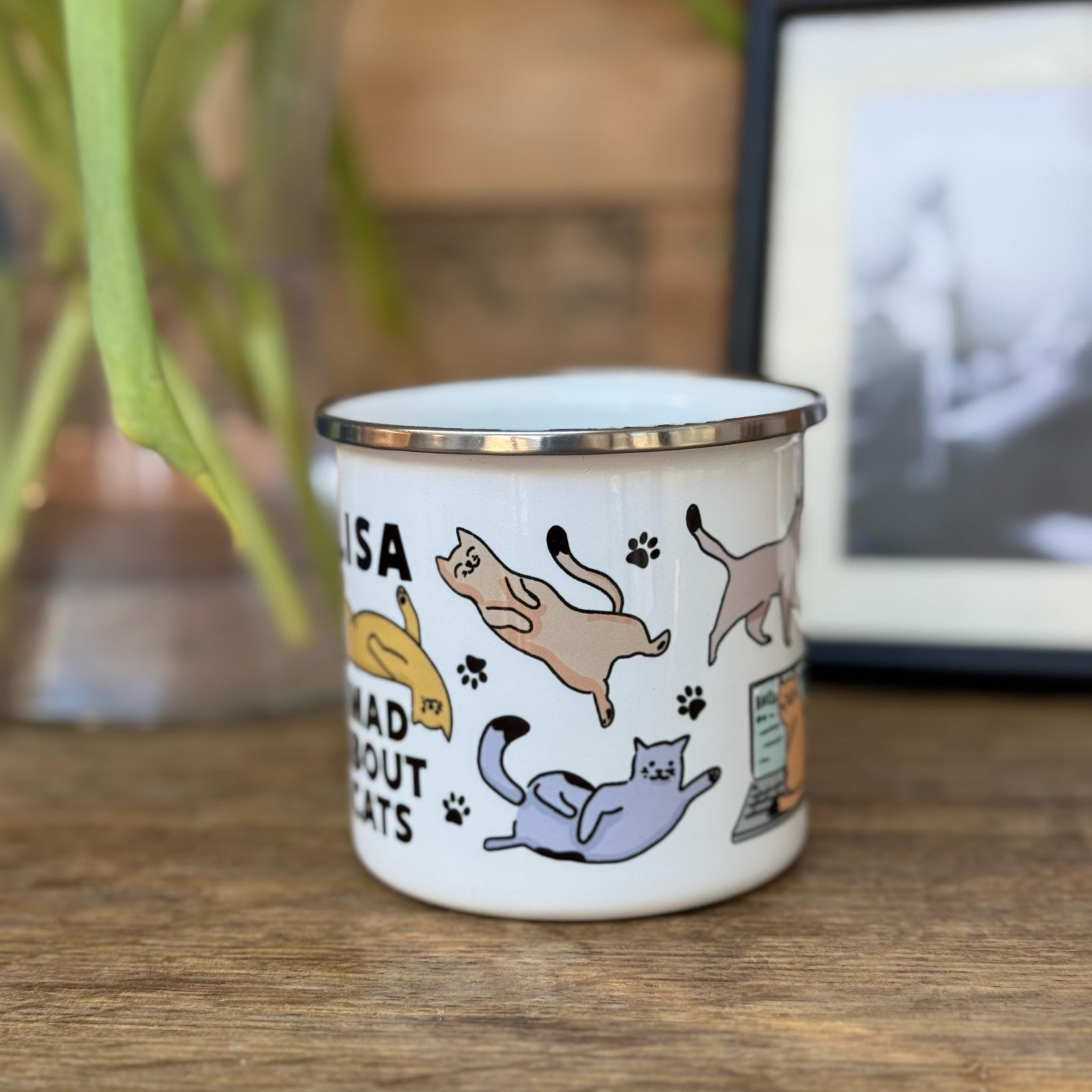 A tin mug with various cat illustrations and the text 'Mad about Cats'