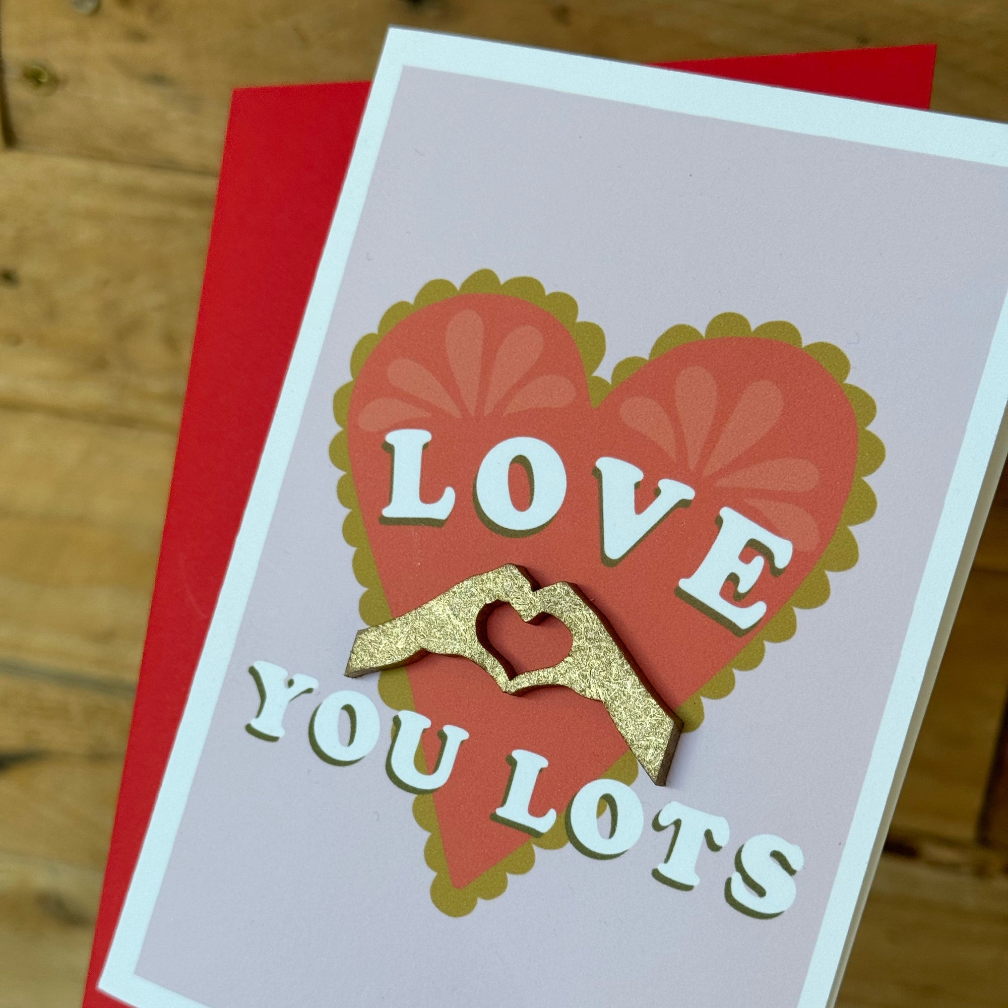 close up of Love you lots greeting card with red heart