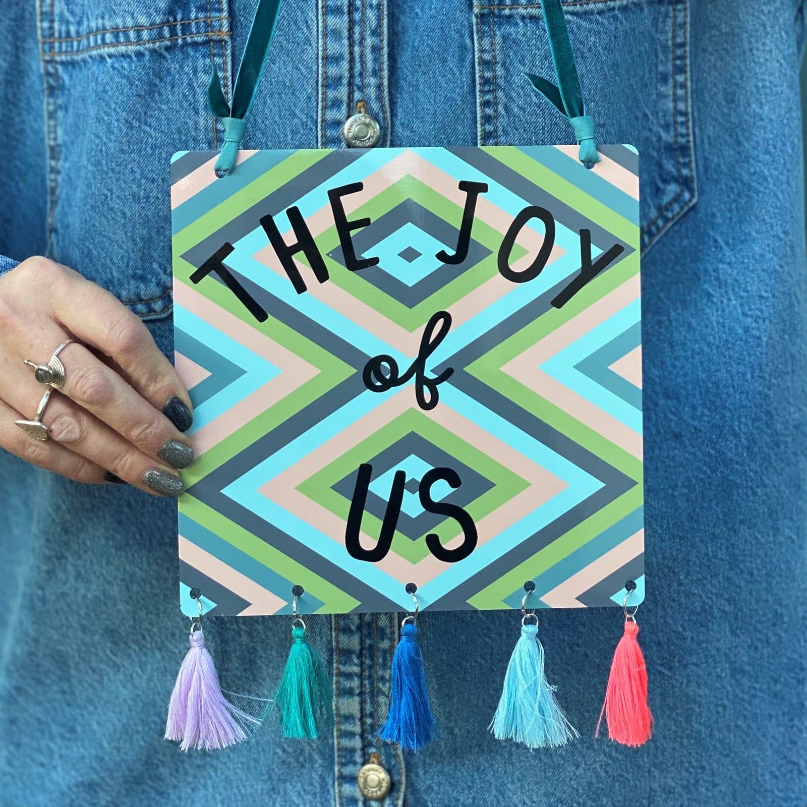 The Joy Of Us Tasselled Metal Sign Pink, Blue Green